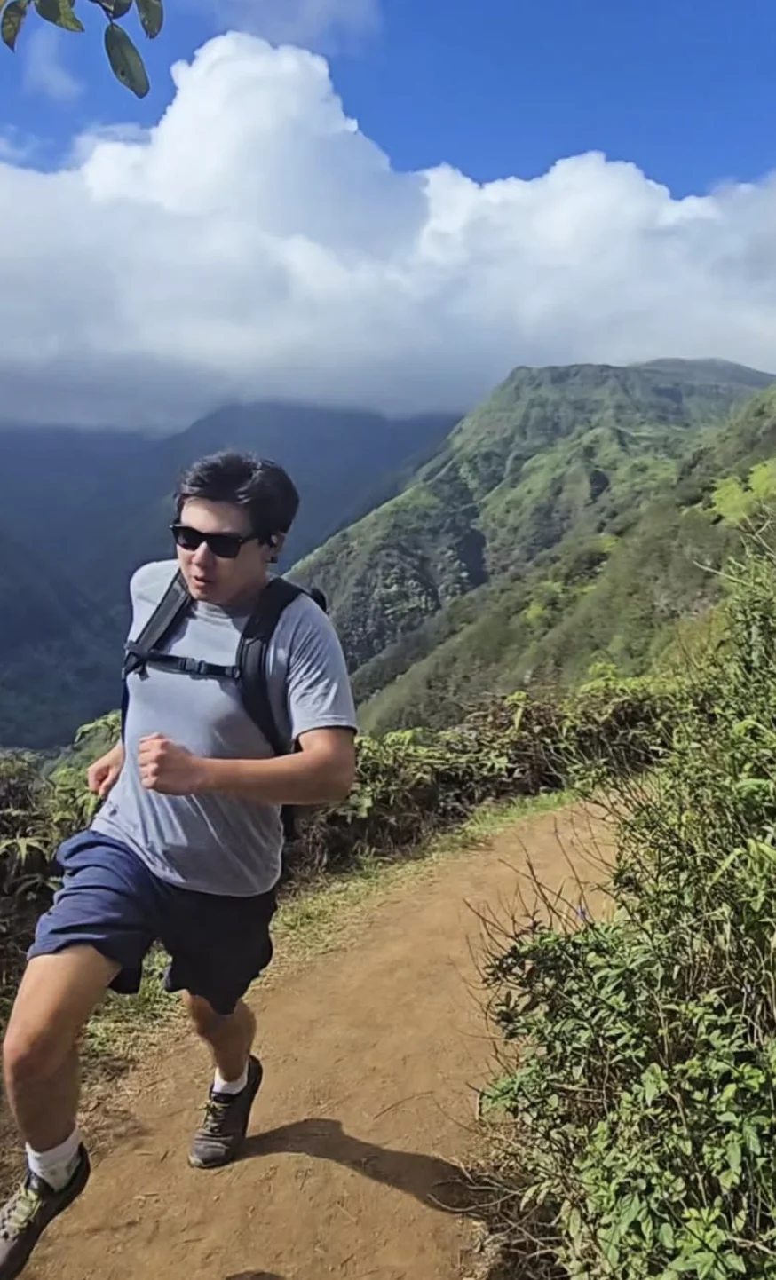 Griffin running on a mountain trail with a backpack