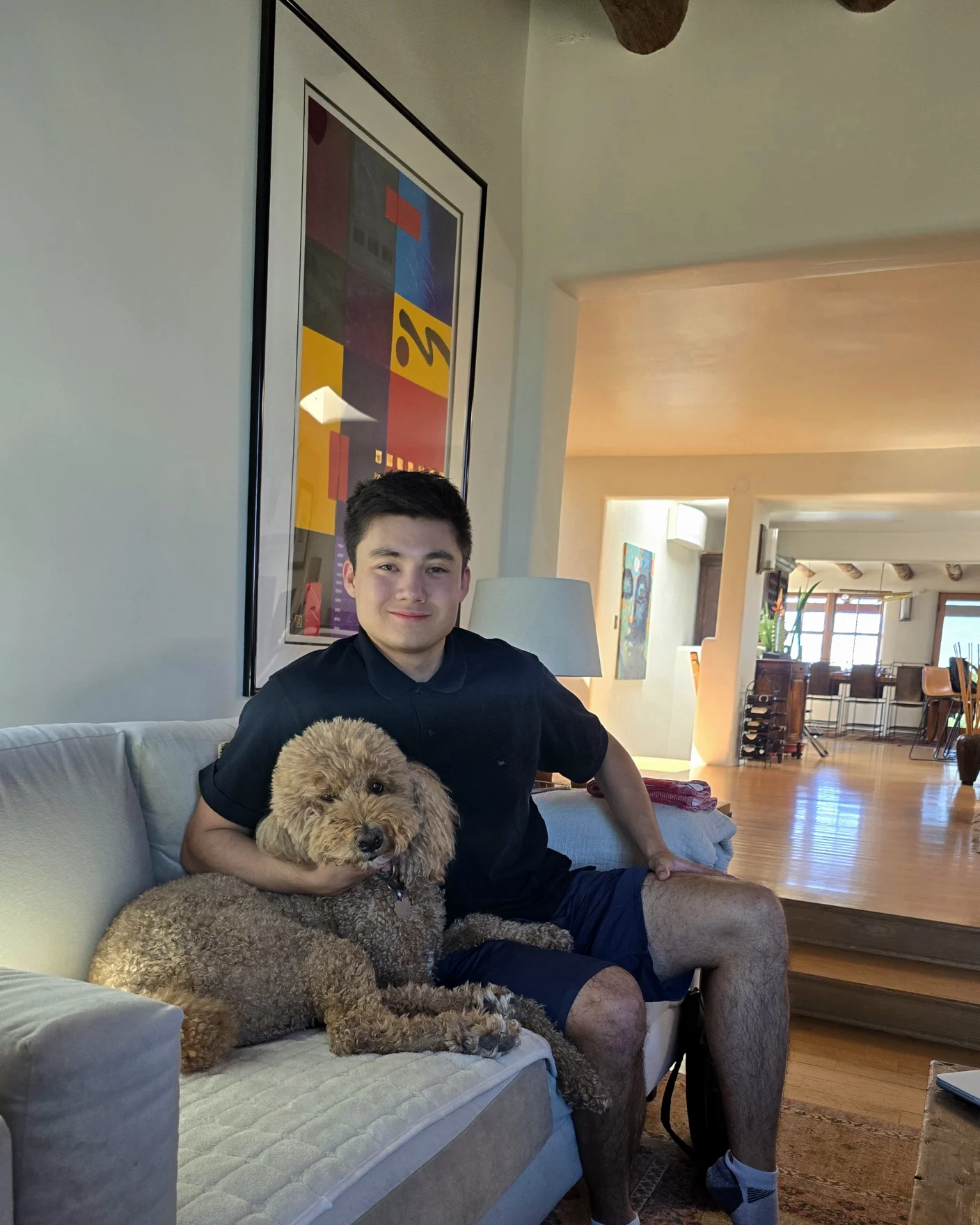 Griffin Rutherford, CTO of Coherascent Labs and creator of Lune Synth, sitting on a couch with his poodle Luna
